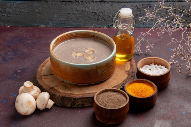 Photo gratuit vue de face savoureuse soupe aux champignons avec différents assaisonnements sur l'espace sombre