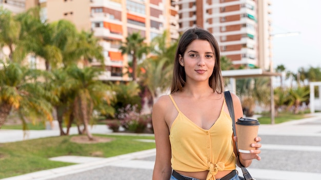 Photo gratuite vue frontale, jeune femme, poser, à, tasse café