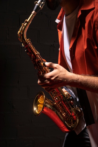 Photo gratuite vue latérale du musicien masculin jouant du saxophone