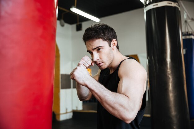 Vue latérale de l'entraînement du boxeur avec punchbag