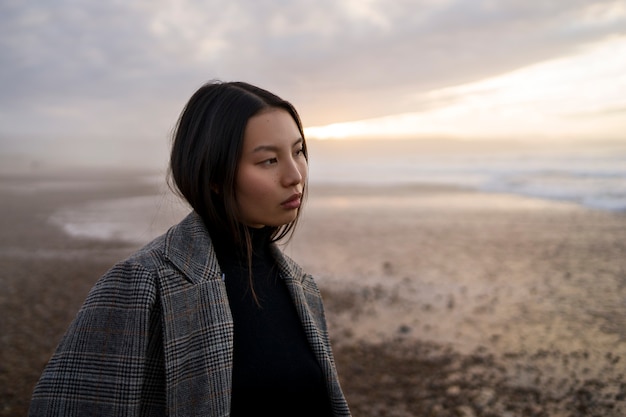 Photo gratuite vue latérale femme appréciant le temps à la plage