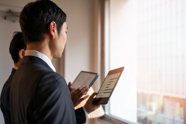 Photo gratuit vue latérale des gens d'affaires travaillant avec ipad