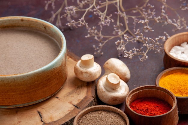 Photo gratuit vue rapprochée avant de la soupe aux champignons savoureuse avec différents assaisonnements sur l'espace violet foncé