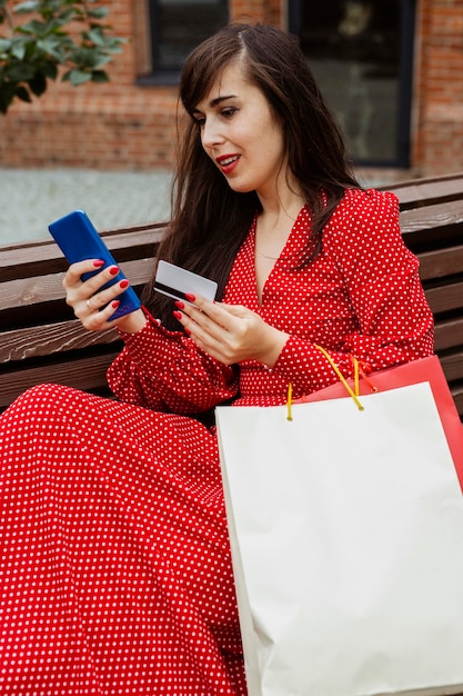 Woman holding smartphone et achat par carte de crédit en ligne pendant les ventes