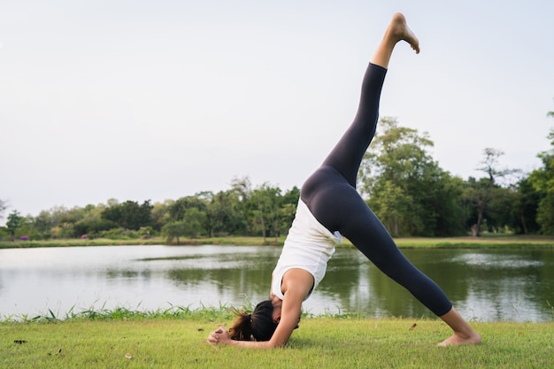 Yoga de jeune femme asiatique à l&#39;extérieur garder son calme et médite tout en pratiquant le yoga