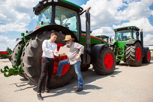 Photo agriculteur professionnel avec une moissonneuse-batteuse moderne sur le terrain au soleil au travail