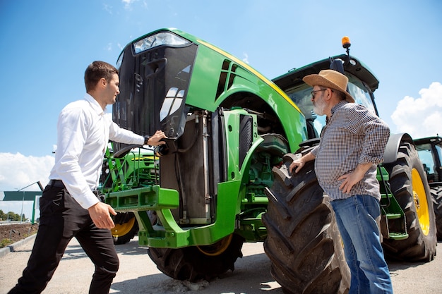 Photo agriculteur professionnel avec une moissonneuse-batteuse de tracteur moderne dans un champ au soleil au travail