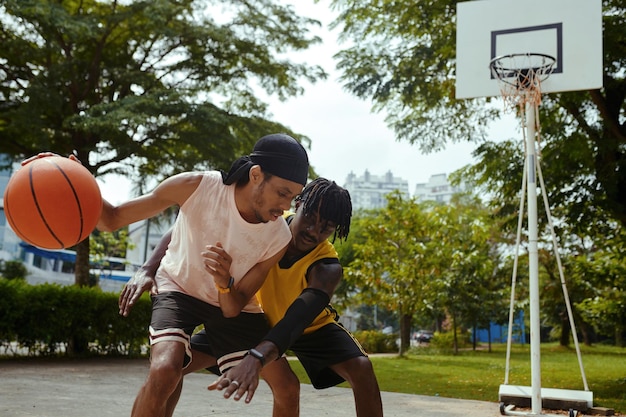 Des amis jouant au streetball.