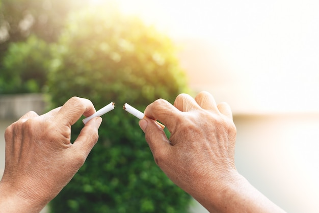 Photo arrête de fumer, jour sans tabac, les mains de la mère cassent la cigarette