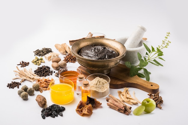 Photo ayurvedic chyawanprash est un puissant booster d'immunité ou un supplément de santé naturel. servi dans un bol antique avec des ingrédients, sur fond de mauvaise humeur, mise au point sélective