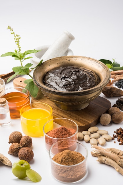 Photo ayurvedic chyawanprash est un puissant booster d'immunité ou un supplément de santé naturel. servi dans un bol antique avec des ingrédients, sur fond de mauvaise humeur, mise au point sélective