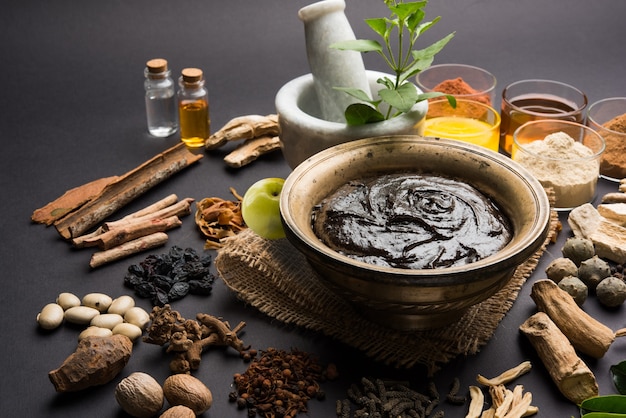 Photo ayurvedic chyawanprash est un puissant booster d'immunité ou un supplément de santé naturel. servi dans un bol antique avec des ingrédients, sur fond de mauvaise humeur, mise au point sélective