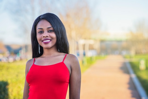 Belle femme afro-américaine posant dans une robe rouge