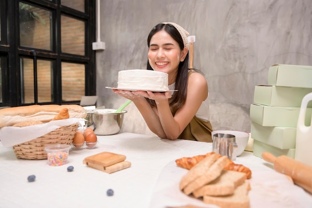 Belle jeune femme fait cuire dans sa cuisine boulangerie et café-restaurant