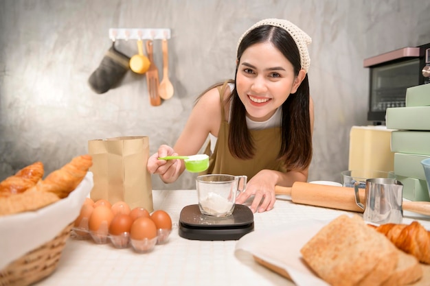 Belle jeune femme fait cuire dans sa cuisine boulangerie et café-restaurant