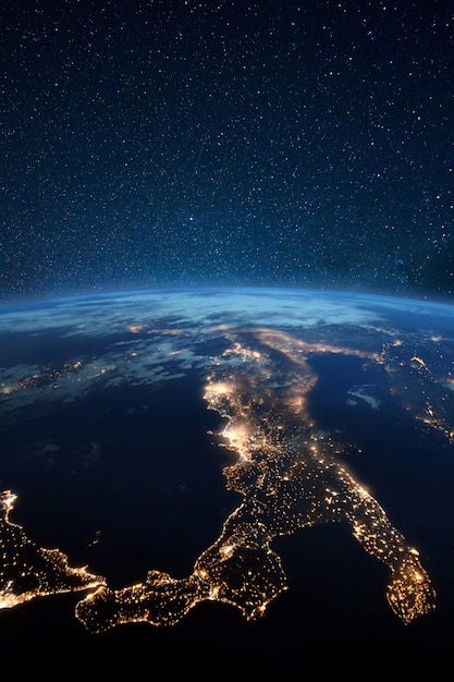 Belle planète terre bleue avec des lumières de la ville de nuit. L'Europe centrale et l'Italie la nuit vue depuis l'espace. Villes modernes et électricité