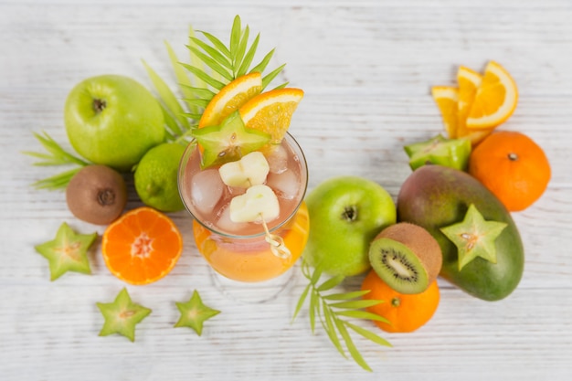 Cocktail d'été avec divers fruits tropicaux autour