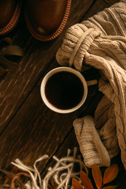 Composition confortable d'automne. Une tasse de café, un plaid, une bougie, des fleurs séchées sur fond clair.