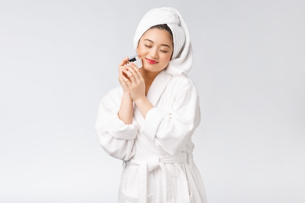 Photo concept de beauté jolie femme asiatique avec une peau parfaite tenant une bouteille cosmétique