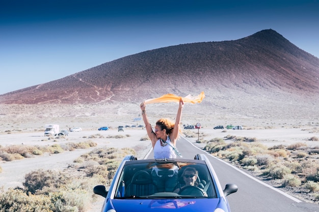 Photo concept de liberté et de voyage pour les femmes caucasiennes adultes indépendantes avec voiture décapotable - personnes voyageant et appréciant l'amitié - concept de conduite et de route