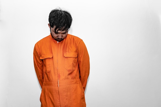 Concept de prisonnier en robe orangePortrait d'un bel homme asiatique en uniforme de prisonLe bandit a beaucoup de muscle