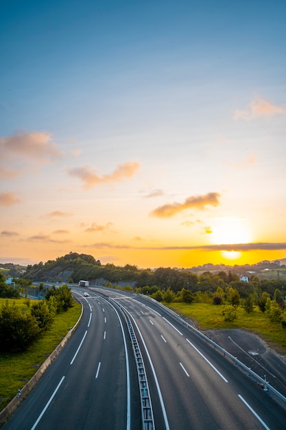 Photo coucher de soleil sur une route, entrez dans les nuages pour couvrir le soleil, photo verticale