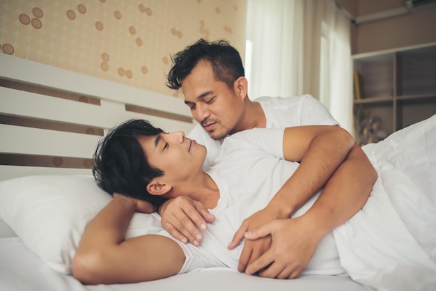 Photo un couple gay amoureux allongé sur le lit à la maison.