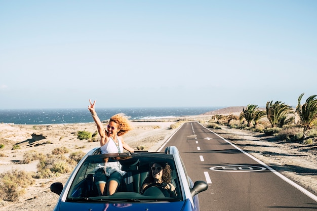 Photo un couple voyage avec une voiture décapotable et profite de la vie en s'amusant