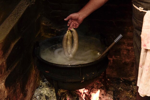 Cuisson du boudin blanc dans une casserole en fer sur une cuisinière