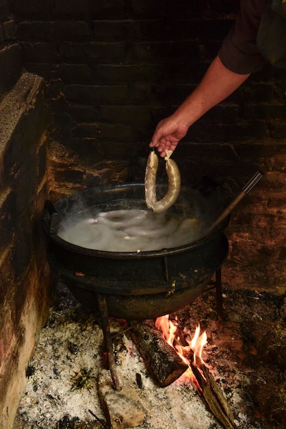 Cuisson du boudin blanc dans une casserole en fer sur une cuisinière