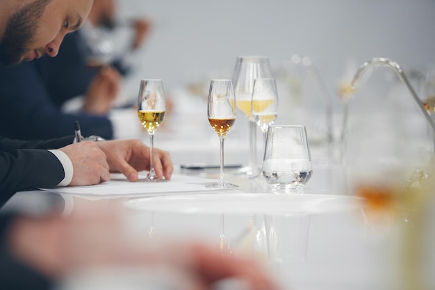 Photo dégustation à l'aveugle de près le sommelier prend des notes sur la carte de dégustation