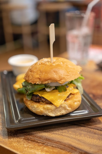 délicieux burger fait maison de fromage de boeuf et de légumes sur une vieille table en bois