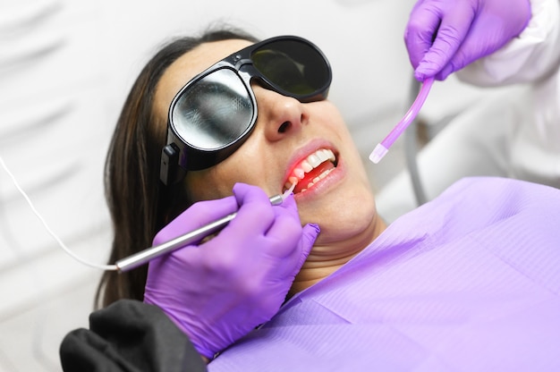 Dentiste à l'aide d'un laser dentaire à diode moderne.