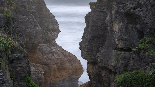 Photo des détails serrés sur des falaises côtières exotiques de forme étrange avec l'océan en arrière-plan en nouvelle-zélande