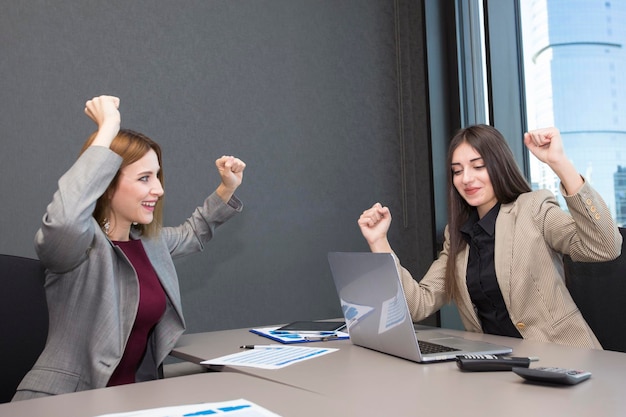 Photo deux femmes d'affaires heureuses qui travaillent au bureau.