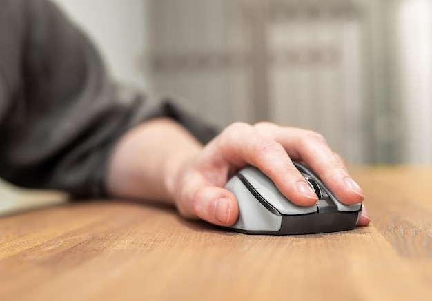 Doigts de la main sur la souris d'ordinateur sur la table en bois bureau concept de moteur de recherche SEO