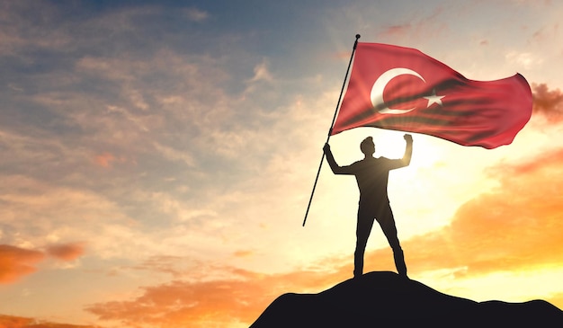 Drapeau de la Turquie agité par un homme célébrant le succès au sommet d'une montagne Rendu 3D