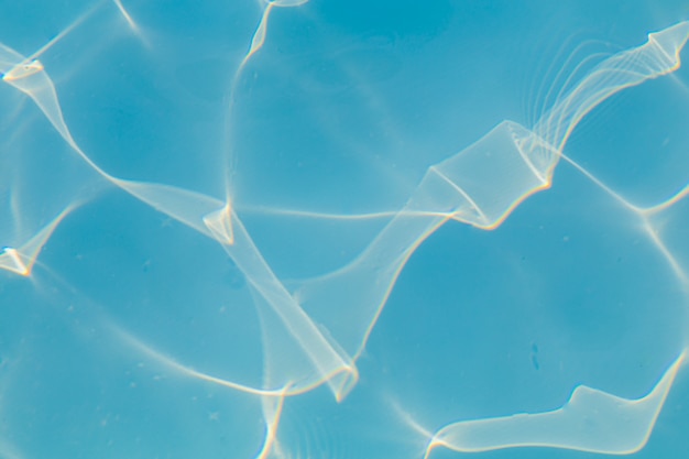 Eau de piscine bleue avec fond de reflets de soleil