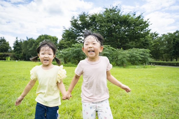 Photo enfants courant dans la prairie du parc