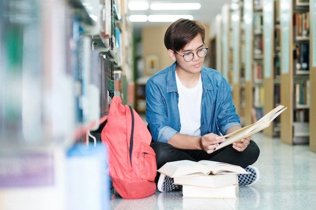 Photo Étudiant assis et étudiant à la bibliothèque