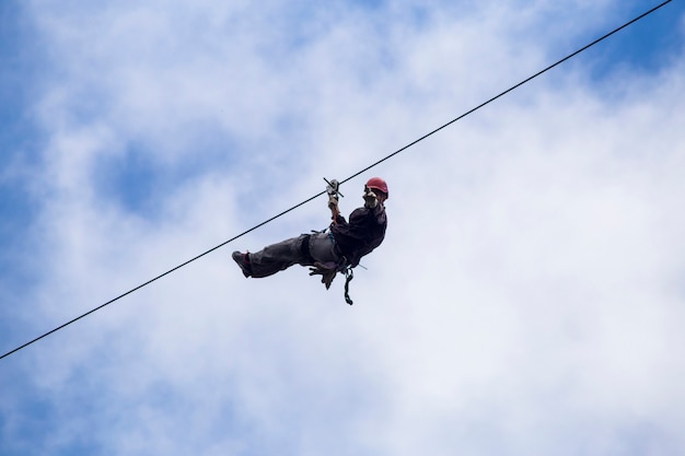 Faible angle de touriste sur la tyrolienne et gesticulant dans le ciel au costa rica