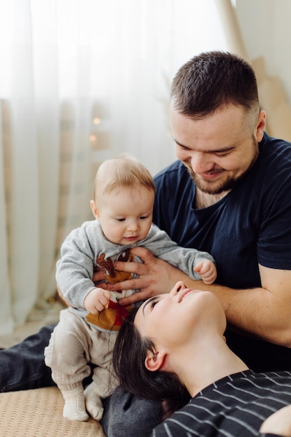 Familles Portrait Of Happy Young Mother And Father with Child Posing In home Interior