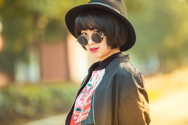 femme asiatique élégante posant dans une rue urbaine