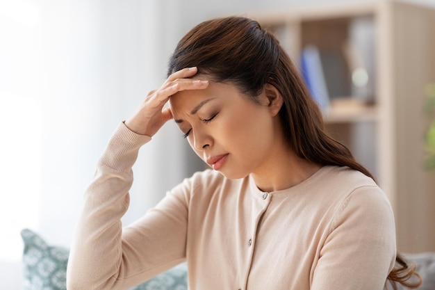 Photo une femme asiatique malade qui a mal à la tête à la maison