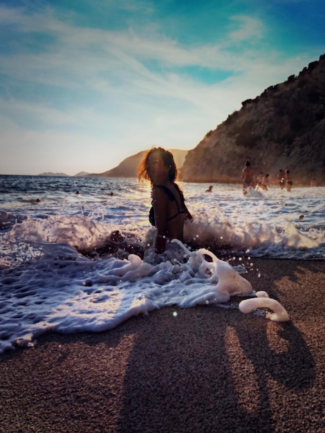 Photo une femme assise sur la plage.