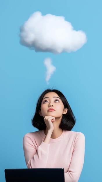 Photo une femme dans un pull rose profondément en pensée avec un nuage au-dessus de sa tête symbolisant la rêverie ou l'imagination sur un fond bleu