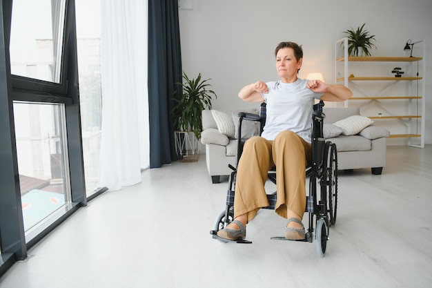 Femme en fauteuil roulant travaillant dans le salon