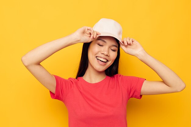 Photo femme gaie d'apparence asiatique dans une casquette posant