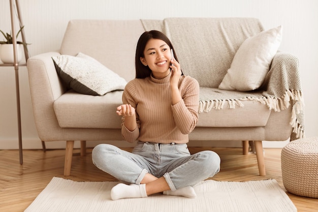 Photo une femme parle au téléphone dans le salon.