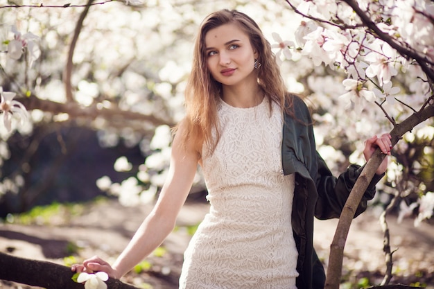 Femme, poser, magnolia, jardin